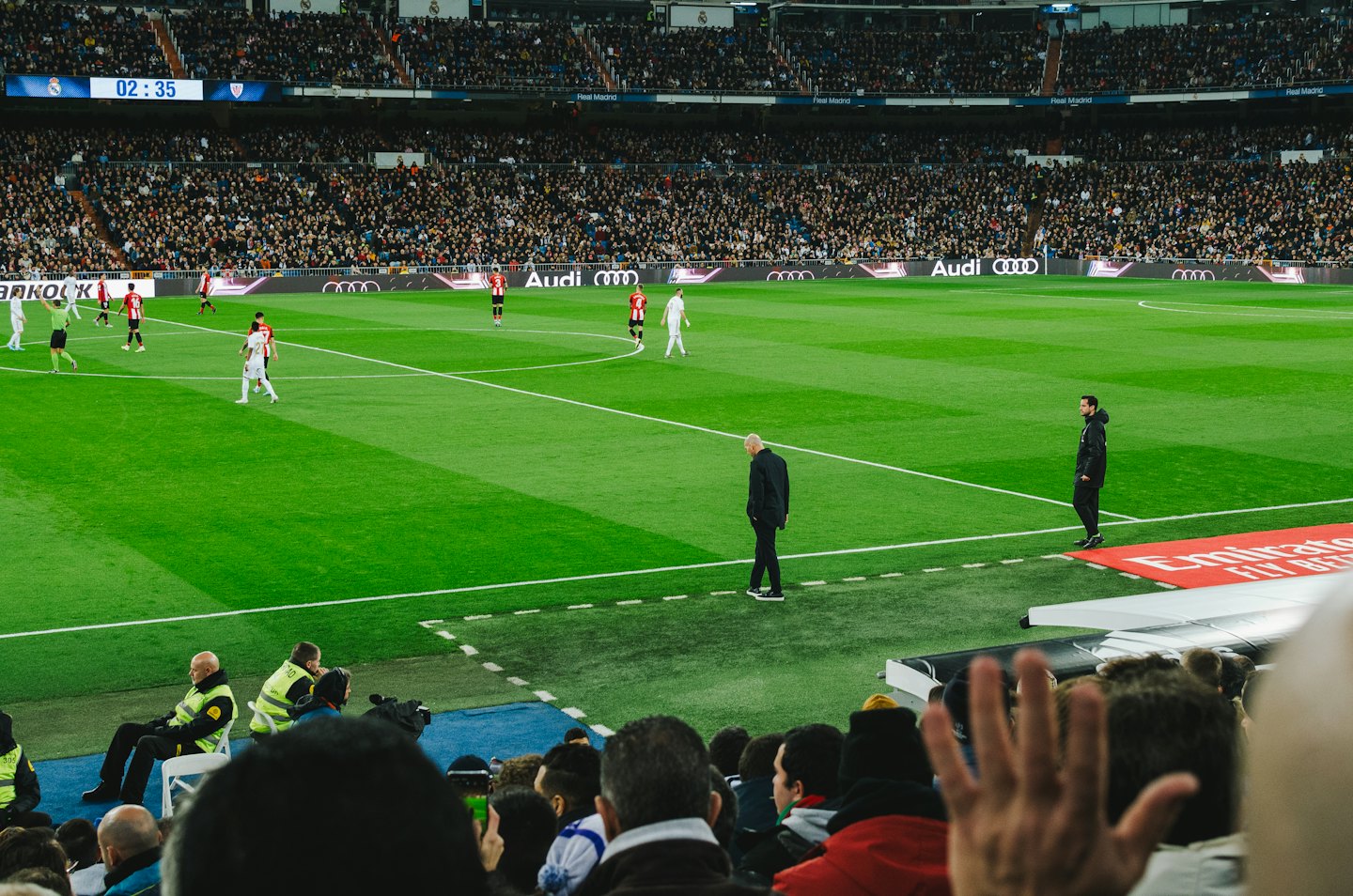 Voetballers strijden op een groen veld in een vol stadion.