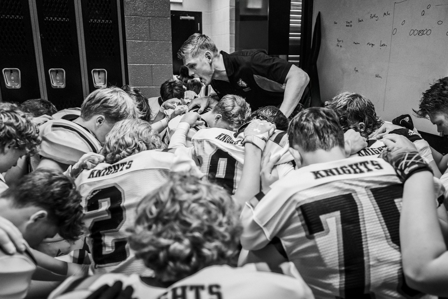 Coach geeft instructies aan een voetbalteam in de kleedkamer.